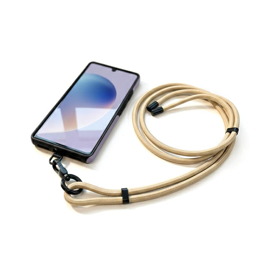 Bandoulière beige avec adaptateur universel installé sur un téléphone, mise en situation