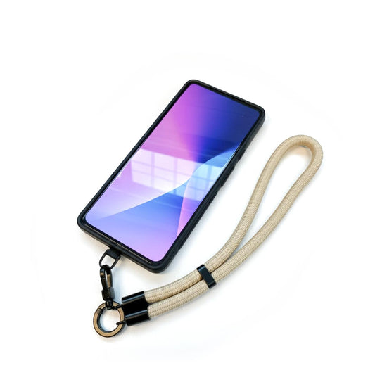 Dragonne beige avec adaptateur universel installé sur un téléphone, mise en situation